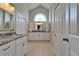 Bright bathroom with dual vanity, granite countertops, and decorative transom window at 1201 Peridot Ln, Sun City Center, FL 33573