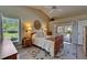 Bright main bedroom with neutral tones, ceiling fan, and access to outdoor pool at 1201 Peridot Ln, Sun City Center, FL 33573