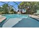 Screened-in pool features a waterfall and lush landscaping for a private backyard oasis at 1201 Peridot Ln, Sun City Center, FL 33573
