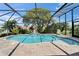Sparkling pool with screened enclosure, beautiful landscaping, and a tranquil waterfall feature at 1201 Peridot Ln, Sun City Center, FL 33573