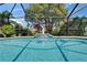 Beautiful pool with a waterfall feature surrounded by vibrant tropical plants at 1201 Peridot Ln, Sun City Center, FL 33573