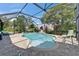 Screened pool features a large deck area, manicured landscaping, and a serene backyard setting at 1201 Peridot Ln, Sun City Center, FL 33573
