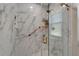Walk-in shower features sleek marble walls, gold fixtures, a built-in shelf, and a window at 1201 Peridot Ln, Sun City Center, FL 33573