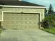 A single car garage features a traditional paneled door and a concrete driveway at 12202 Fairlawn Dr, Riverview, FL 33579