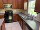 Kitchen featuring stainless steel appliances, dark cabinets, tile flooring, and gray counter tops at 12202 Fairlawn Dr, Riverview, FL 33579