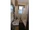 Bathroom featuring a toilet, sink and walk-in shower behind a curtain, with a small window at 1221 E Osborne Ave, Tampa, FL 33603