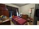 A bedroom with a bed, dresser, and window, with peeling paint on the wall and a dark curtain at 1221 E Osborne Ave, Tampa, FL 33603