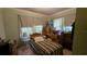 Modest bedroom with a twin bed, small table, dresser, and two windows allowing natural light at 1221 E Osborne Ave, Tampa, FL 33603