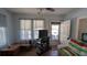 A living room with a ceiling fan, a set of windows, and wooden furniture with some electronics at 1221 E Osborne Ave, Tampa, FL 33603