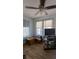 A living room with a ceiling fan, a set of windows, and wooden furniture with some electronics at 1221 E Osborne Ave, Tampa, FL 33603