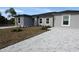 New construction features gray stucco and paved driveway with desert landscaping at 12223 Kirk Ave, Port Charlotte, FL 33981