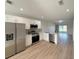 Open-concept kitchen features stainless steel appliances, white cabinetry and overlooks an outdoor area, combining style with functionality at 12223 Kirk Ave, Port Charlotte, FL 33981