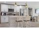 Well-equipped kitchen with white cabinetry, center island, stainless steel appliances and two pendant lights at 12266 Edwards Rd, Port Charlotte, FL 33981