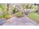 Paver patio overlooks a lush backyard featuring mature trees and green grass at 1249 Abbey Crescent Ln, Clearwater, FL 33759