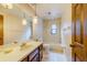 Bathroom featuring a vanity, toilet, and a shower-tub combo with unique pendant lighting at 1249 Abbey Crescent Ln, Clearwater, FL 33759