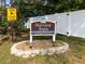 Harvard Arms Townhomes community sign with children playing sign, nice landscaping, and white fencing at 1249 Abbey Crescent Ln, Clearwater, FL 33759