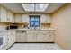 Cozy kitchen featuring white appliances, ample cabinet space, and a bright skylight at 1249 Abbey Crescent Ln, Clearwater, FL 33759