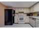 Well-lit kitchen featuring a black refrigerator and ample cabinet space at 1249 Abbey Crescent Ln, Clearwater, FL 33759