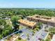 Aerial view of community buildings, pool, parking, trees, and the ocean in the background at 12760 Indian Rocks Rd # 410, Largo, FL 33774