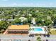 Aerial view of community pool and lounge chairs with lush landscaping and residential neighborhood in the background at 12760 Indian Rocks Rd # 410, Largo, FL 33774