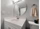 Cozy bathroom features a round mirror, modern sink, and a neutral color scheme, creating a relaxing atmosphere at 12760 Indian Rocks Rd # 410, Largo, FL 33774
