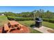 Grilling area with a picnic table, grill, and lush landscaping, ideal for outdoor cooking and dining at 12760 Indian Rocks Rd # 410, Largo, FL 33774