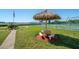 Outdoor recreational area featuring a thatched-roof seating area, tennis court, and well-manicured lawn at 12760 Indian Rocks Rd # 410, Largo, FL 33774