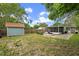 Large backyard featuring lush greenery, a storage shed, and a screened lanai for outdoor enjoyment at 1408 Michigan Ave, Palm Harbor, FL 34683