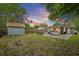 Large backyard with greenery, a storage shed, and a screened lanai, perfect for outdoor relaxation and storage at 1408 Michigan Ave, Palm Harbor, FL 34683