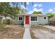 Charming home featuring a bright red front door and inviting curb appeal at 1408 Michigan Ave, Palm Harbor, FL 34683