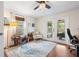 Office with wooden floors, ceiling fan, and sliding glass doors to a cozy, screened patio at 1408 Michigan Ave, Palm Harbor, FL 34683