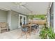 Relaxing screened porch with ceiling fans, stylish dining set, and views of the landscaped backyard at 1408 Michigan Ave, Palm Harbor, FL 34683