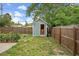 Backyard storage shed with a wooden door, and surrounded by a wooden fence, and maintained yard at 1408 Michigan Ave, Palm Harbor, FL 34683
