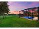 Backyard view of the screened-in pool, spa, and golf course at 1416 Via Verdi Dr, Palm Harbor, FL 34683