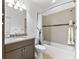 Bathroom featuring dark wood vanity with granite countertop and tiled shower-tub adding warmth and elegance to the space at 1416 Via Verdi Dr, Palm Harbor, FL 34683
