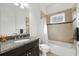 Bathroom featuring granite countertop vanity, decorative mirror, and tiled shower-tub with a neutral color palette at 1416 Via Verdi Dr, Palm Harbor, FL 34683