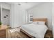 Bedroom with white walls, a wood bed frame with white linens, and natural light creating a serene and inviting atmosphere at 1416 Via Verdi Dr, Palm Harbor, FL 34683