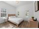 Bright bedroom featuring a wood bed frame, two windows with shutters, and wood-style floors providing warmth and natural light at 1416 Via Verdi Dr, Palm Harbor, FL 34683
