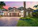 Beautiful single-story home featuring a three-car garage, well-manicured lawn, and tasteful stone and stucco accents at 1416 Via Verdi Dr, Palm Harbor, FL 34683