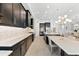 Contemporary kitchen with stylish dark cabinets, stainless steel appliances, and an oversized island with seating at 1416 Via Verdi Dr, Palm Harbor, FL 34683