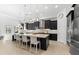 Modern kitchen boasts an island with seating, dark cabinets, stainless steel appliances, and elegant pendant lighting at 1416 Via Verdi Dr, Palm Harbor, FL 34683