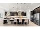 Elegant kitchen featuring dark cabinetry, modern lighting, stainless steel appliances and a large island at 1416 Via Verdi Dr, Palm Harbor, FL 34683