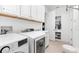 Bright laundry room featuring modern washer and dryer, white cabinets, and ample storage space at 1416 Via Verdi Dr, Palm Harbor, FL 34683