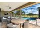 Covered patio includes wicker furniture, a ceiling fan, and view of pool overlooking the golf course at 1416 Via Verdi Dr, Palm Harbor, FL 34683