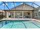 Pool and covered patio boasts an outdoor kitchen and views of golf course at 1416 Via Verdi Dr, Palm Harbor, FL 34683