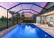 Screened-in in-ground pool and spa with serene golf course views during sunset at 1416 Via Verdi Dr, Palm Harbor, FL 34683