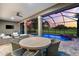 Covered outdoor patio features an in-ground pool with serene views of the golf course at 1416 Via Verdi Dr, Palm Harbor, FL 34683