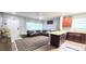 Open-concept living room featuring a comfortable sectional sofa, adjacent to the kitchen with granite countertops at 15124 Deer Meadow Dr, Lutz, FL 33559