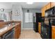 Functional kitchen with stainless steel sink, black appliances, and tile flooring at 1603 Fluorshire Dr, Brandon, FL 33511