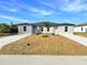 Charming duplex featuring a well-manicured lawn and a shared yard with young palm tree at 17099 Carleen Ave, Port Charlotte, FL 33948